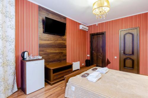 a bedroom with a bed and a tv on a wall at Poznyakoff Aparthotel in Kyiv