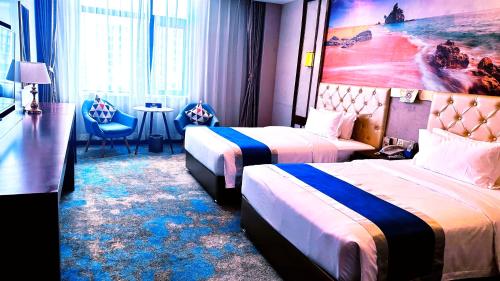 a hotel room with two beds and a table and chairs at 怡程酒店ECHENG HOTEL in Sihanoukville