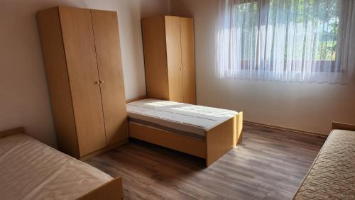 a small room with two beds and a window at Kuća djeda Ive 