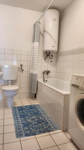 a bathroom with a tub and a toilet and a sink at Kuća djeda Ive 