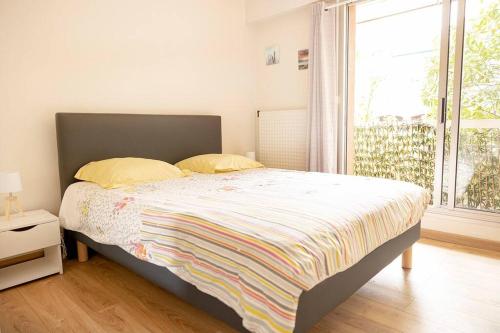 ein Schlafzimmer mit einem Bett und einem großen Fenster in der Unterkunft Moana Haven Biarritz - Plages - Golf - WIFI - Standing in Anglet
