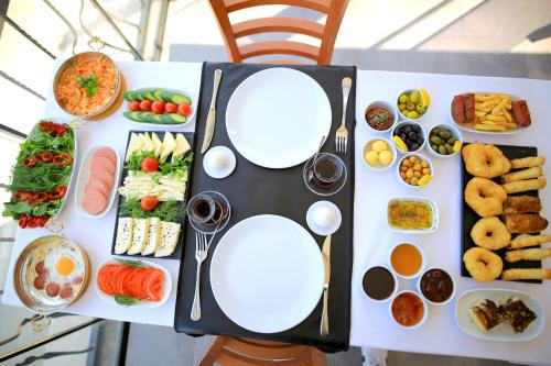a table with plates of food and appetizers at Çamlık 87 Hotel Ayvalık in Ayvalık