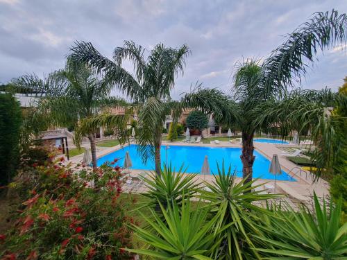 a large pool with palm trees and plants at Urania Luxury Suite with pool view -Loutra Resort in Loutra