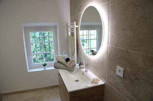 een badkamer met een wastafel en een spiegel bij La Bastide au coeur de la Provence in Pertuis