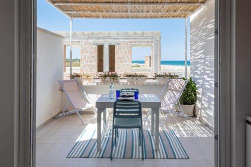 een tafel en stoelen op het balkon van een huis bij Palamì - Polignano a Mare Holiday House in Polignano a Mare
