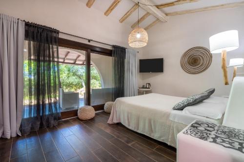 1 dormitorio con cama y ventana grande en Hotel Galanias, en Bari Sardo