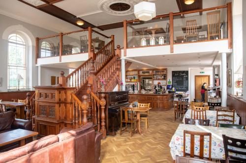 een restaurant met tafels en stoelen en een trap bij Pontcysyllte Chapel Tearoom in Llangollen