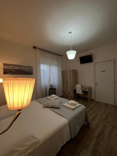 a bedroom with a bed with a lamp and a table at Giardino dei Baroni house in Marina di Mancaversa