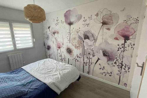 a bedroom with a flower mural on the wall at Les cyclamens in Quend