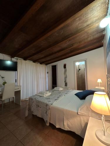 a bedroom with a large bed with a table and a desk at Giardino dei Baroni house in Marina di Mancaversa