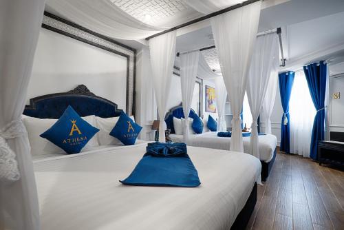 a bedroom with two beds with blue and white pillows at Athena Hotel Quy Nhơn in Quy Nhon