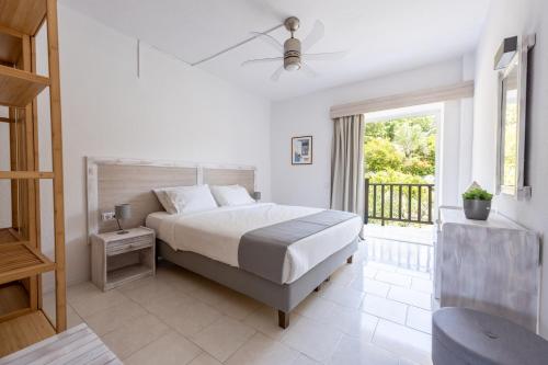 a white bedroom with a bed and a window at Spathies in Kalogria