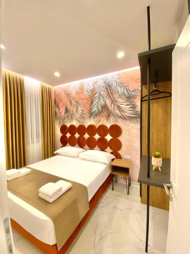 a bedroom with a large bed with a painting on the wall at Apartments Oda Hotel in Velipojë