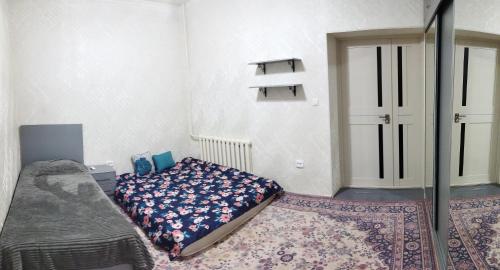 1 dormitorio con cama y puerta con alfombra en Family house, en Tashkent