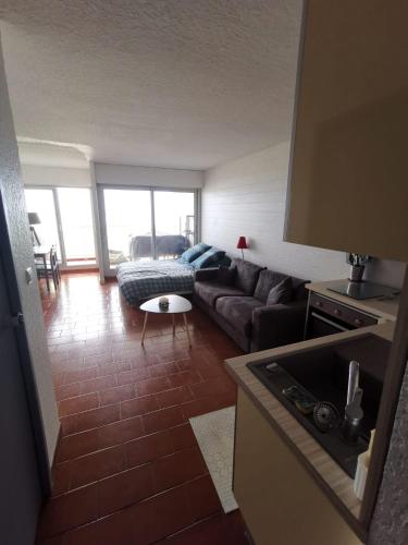 un salon avec un canapé et une table dans l'établissement Cosy 4 studio front de mer, à Canet