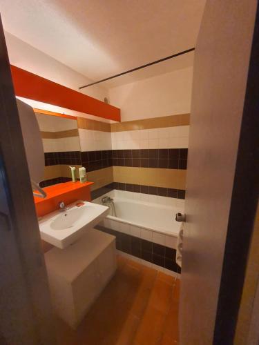 une salle de bain avec un lavabo et une baignoire dans l'établissement Cosy 4 studio front de mer, à Canet