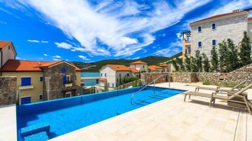 路思提卡的住宿－Lustica Bay Marina Village by 2BHome，一座带游泳池和房子的别墅