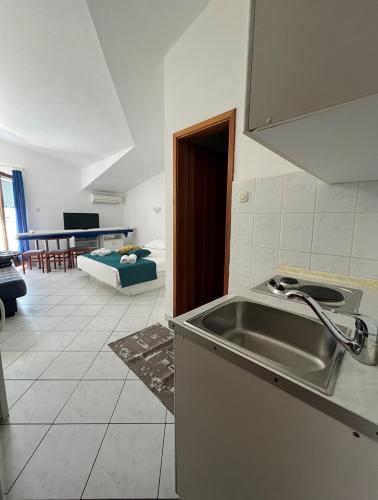 uma cozinha com um lavatório e uma sala de estar em Villa Bianca with private Beach and Parking em Neum