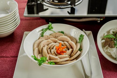 a bowl of food on a table with other dishes at GREENECO DA LAT HOTEL - Khách sạn Green Eco Đà Lạt in Da Lat