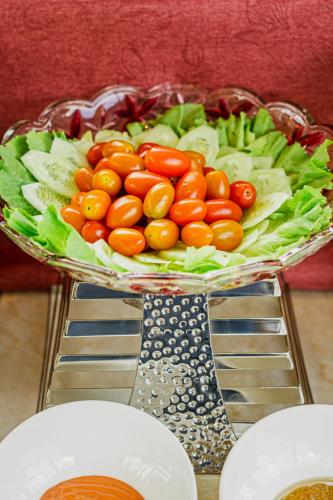 a plate of tomatoes lettuce and other vegetables on a table at GREENECO DA LAT HOTEL - Khách sạn Green Eco Đà Lạt in Da Lat