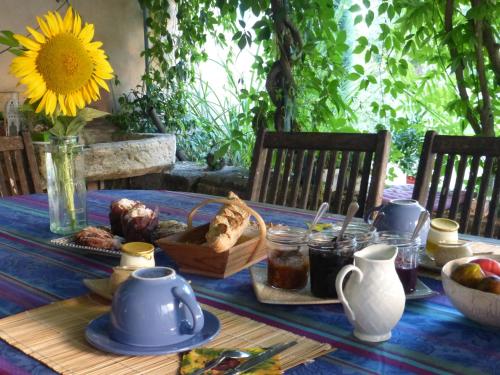 einen Tisch mit einem blauen Tischtuch und einer Sonnenblume in der Unterkunft Domaine du Coffre in Pertuis