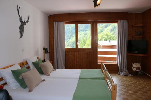 a bedroom with two beds and a large window at Le Vieux Valais in Ovronnaz