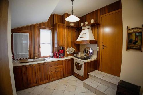 a kitchen with wooden cabinets and a sink and a window at Iris Villa with Swimming Pool in Áno Lekhónia