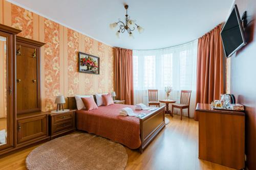 a bedroom with a bed and a table in a room at Poznyakoff Aparthotel in Kyiv