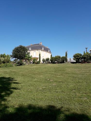 a large house in a field of green grass at Domaine De l'Ourbise in Razimet