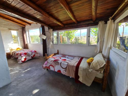a bedroom with two beds in a room with windows at Espacio Nux in Los Árboles