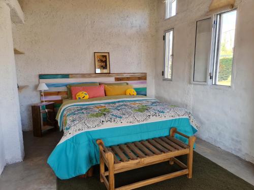 a bedroom with a bed with a bench in it at Espacio Nux in Los Árboles