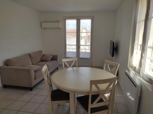 un salon avec une table et un canapé dans l'établissement Appartement calme et cosy, à Avignon