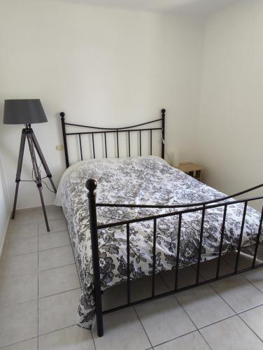 une chambre avec un lit avec une couverture et un trépied dans l'établissement Appartement calme et cosy, à Avignon