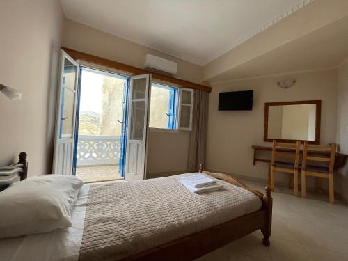 a bedroom with a bed and a view of a balcony at Hotel THE OLIVE TREE in Olympos