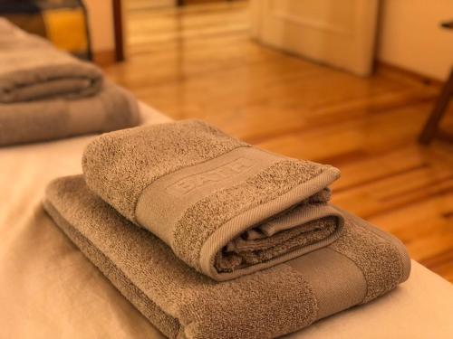 a pile of towels sitting on top of a bed at Maison Biscuit. Apartament a la plaça de la vila in Camprodon