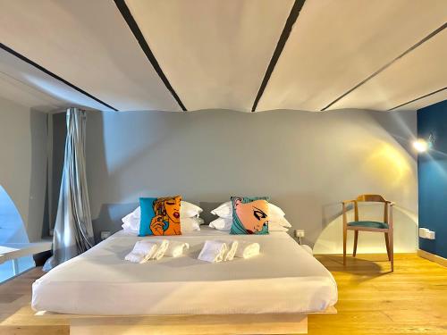 a bedroom with a white bed with colorful pillows at Trastevere Loft in Rome