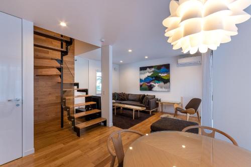 a dining room and living room with a table and chairs at Furano Lofts in Furano