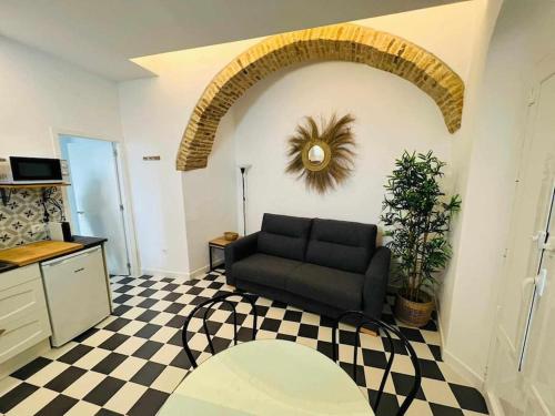 een woonkamer met een bank en een geruite vloer bij Casa Las 4 Esquinas by Casas con Encanto in Medina Sidonia