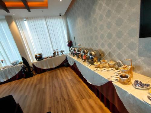 a long table with tea pots and dishes on it at رؤوم ان للشقق الفندقية- Raoum Inn Hotel Apartments-Sakaka in Sakakah