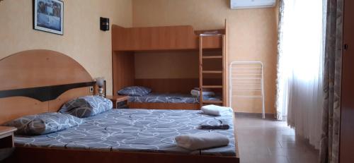 a bedroom with a large bed and bunk beds at Family Hotel California - Varna in Varna City