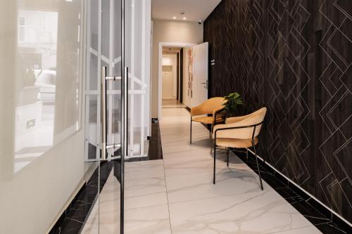 a hallway with two chairs and a wall at Urban Isle in Il-Gżira
