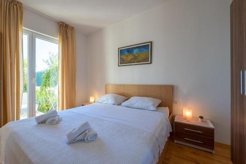 um quarto com uma cama com duas toalhas em Apartments Jele em Zavala