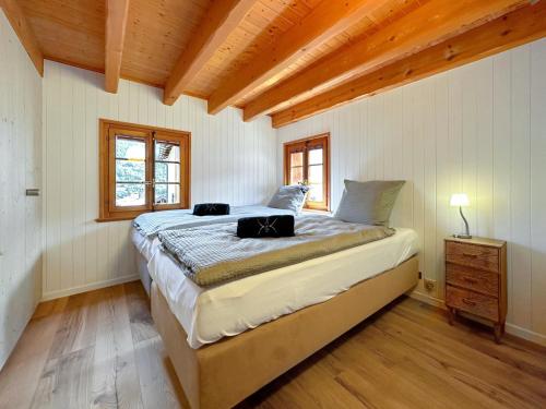 ein Schlafzimmer mit einem großen Bett in einem Zimmer mit Holzdecken in der Unterkunft Chalet Karibu - 4 Vallees - A 20 mns de Verbier in Bruson