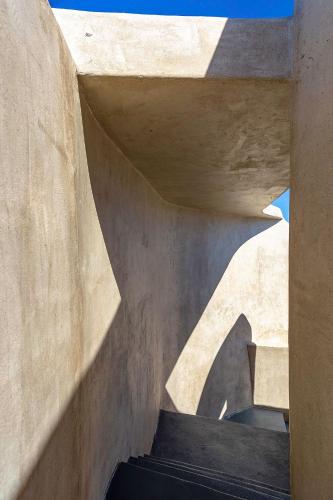 a concrete stairway in a building with a shadow at Senses Luxury Houses in Fira