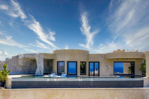 a house with a swimming pool in front of it at Senses Luxury Houses in Fira