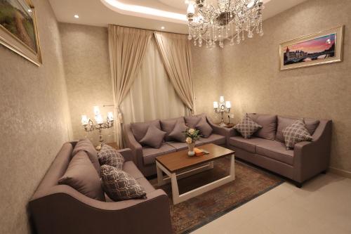 a living room with couches and a chandelier at سما الرفاع 3 in Al Kharj