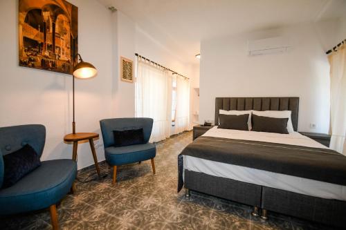 een slaapkamer met een bed, 2 stoelen en een lamp bij Swan Boutique Hotel in Bodrum City