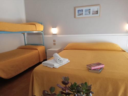 um quarto de hotel com duas camas com toalhas e uma planta em Hotel Haiti em Milano Marittima