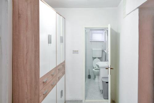La salle de bains est pourvue de toilettes et d'une porte en verre. dans l'établissement Apartman Karmen, à Kaštela