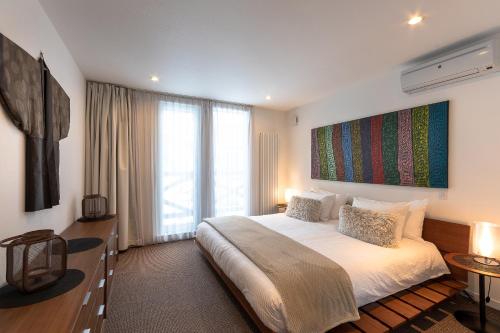 a bedroom with a large bed and a large window at Furano Lofts in Furano